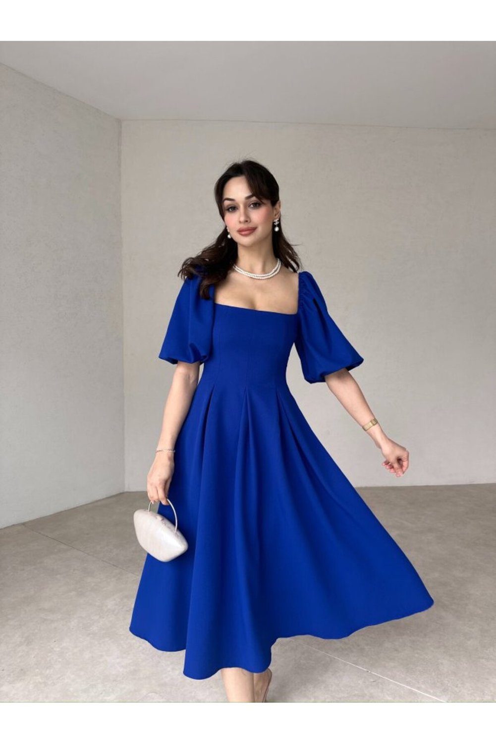 A medium-length dress with a square neckline and balloon sleeves