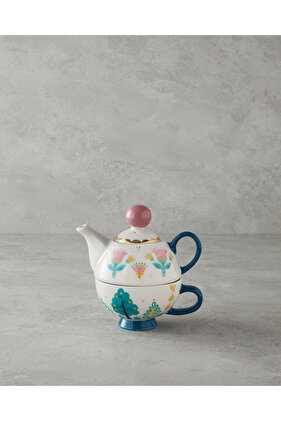 كوب صيني باللون الأخضر والوردي مع إبريق شاي ودافئ