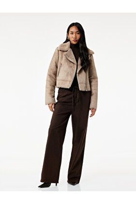 سترة بأزرار على الجهتين ذات ياقة طويلة الأكمام وجيب بسحاب وياقة من الفرو الصناعي وسترة قصيرة من جلد الغزال الصناعي