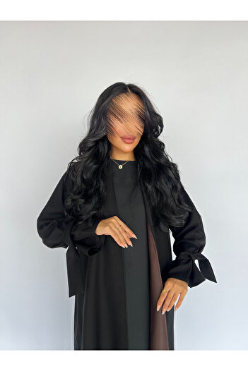 outline Practical black abaya made of rattan fabric, lined with brown silk fabric, with hidden pockets.