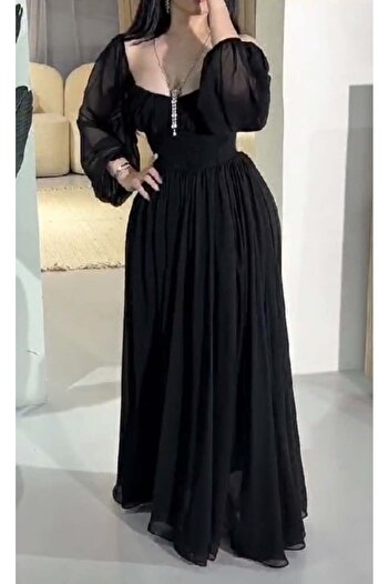 Riva Long black dress, with sheer puffy sleeves and a narrow waist.