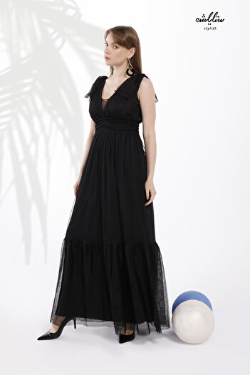 Stylish Feminine long black dress made of soft tulle, off-the-shoulder, with pleats around the waist