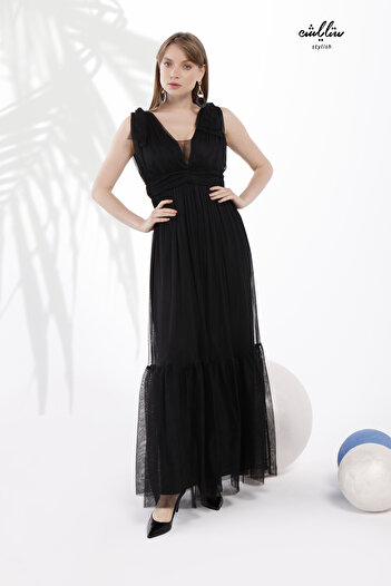 Stylish Feminine long black dress made of soft tulle, off-the-shoulder, with pleats around the waist