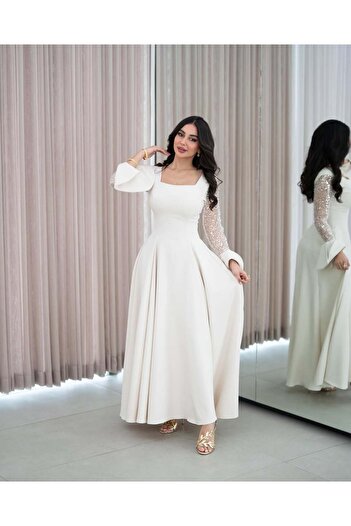 Riva Ivory white wedding dress with long sleeves embellished with sequins.