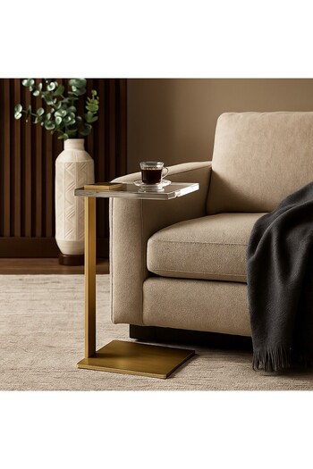 Vi Markets A modern side table with an acrylic top and an elegant golden base adds a touch of luxury to the space.