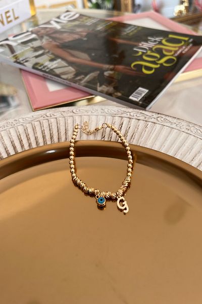 Trendy Butik سوار دوريكا مع حرف G وعين الشر المتدلية