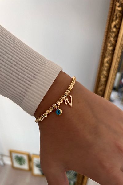Trendy Butik سوار دوريكا مع حرف V وعين الشر المتدلية