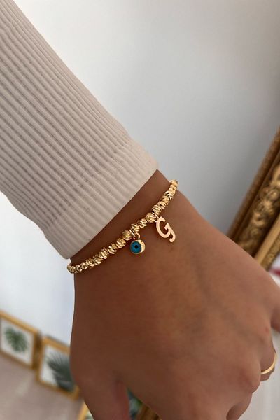 Trendy Butik سوار دوريكا مع حرف G وعين الشر المتدلية