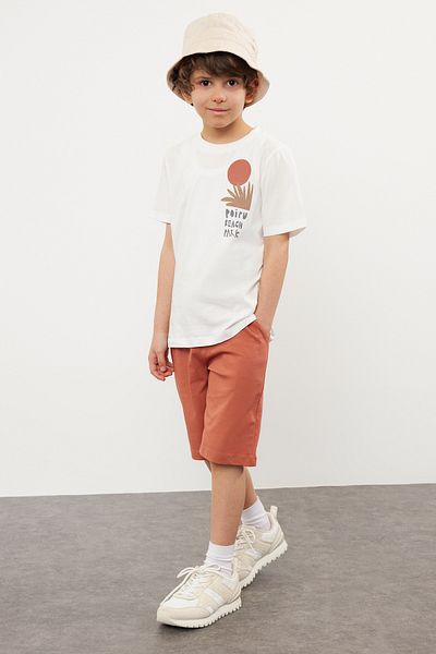 TRENDYOLKIDS طقم محبوك باللون الأزرق الداكن للأولاد - تي شيرت وسروال قصير مصنوع من القطن بنسبة 100% مع طباعة خلفية TKDSS24AU00008