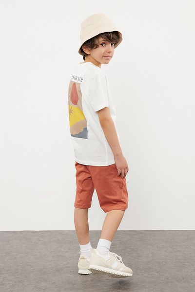 TRENDYOLKIDS طقم محبوك باللون الأزرق الداكن للأولاد - تي شيرت وسروال قصير مصنوع من القطن بنسبة 100% مع طباعة خلفية TKDSS24AU00008