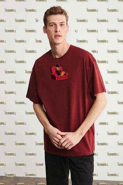 aynewmoda тениска с голям размер и щампа на черно пате, седнала на дивана