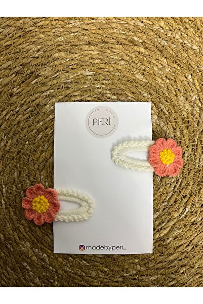 MADE BY PERİ A pair of Snaps buckles on a beige colored floor with lilac, cor...