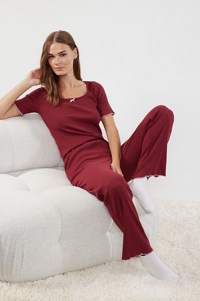 Trendyol Collection Weinrotes Baby-Pyjama-Set aus gerippter Baumwolle mit Overlock- und Banddetails THMAW25PT00027