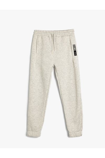 Koton Jogger tepláky ze směsi bavlny – potištěný slogan, šněrovací pas a detail kapsy
