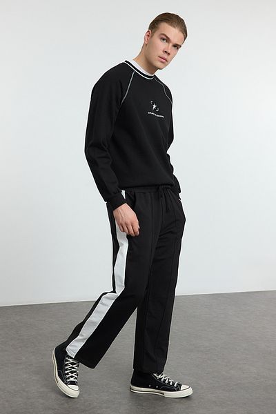 Trendyol Collection Spodnie dresowe oversize z otwartymi nogawkami w kolorze czarnym - Tmnaw25Ea00006