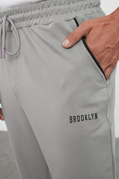 Trendyol Collection Šedé tepláky Regular Fit - Gumové nohavice s potiskem a paspulí TMNSS22EA0121