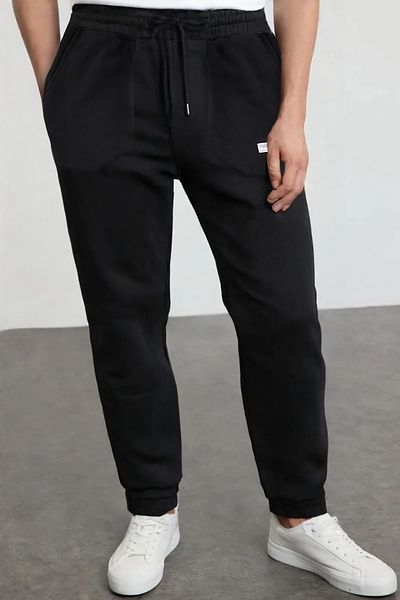 Trendyol Collection Schwarze Sweatpants mit normaler Passform - Taschen genäht TMNSS23EA00010