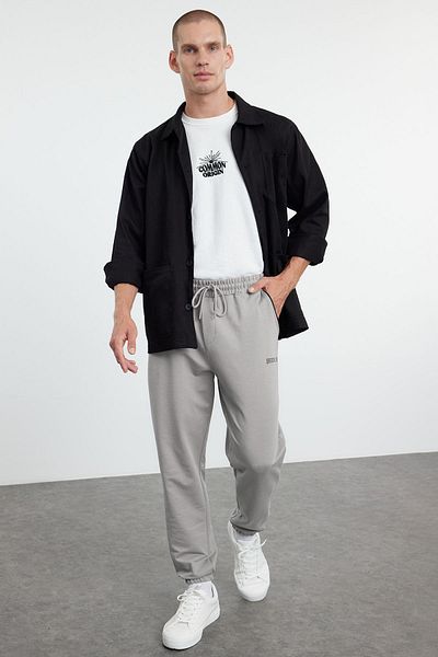 Trendyol Collection Graue Jogginghose mit normaler Passform – bedrucktes und paspeliertes Gummibein TMNSS22EA0121