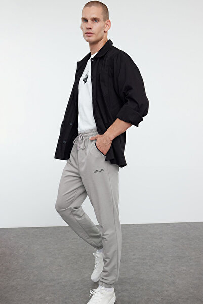 Trendyol Collection Šedé tepláky Regular Fit - Gumové nohavice s potiskem a paspulí TMNSS22EA0121