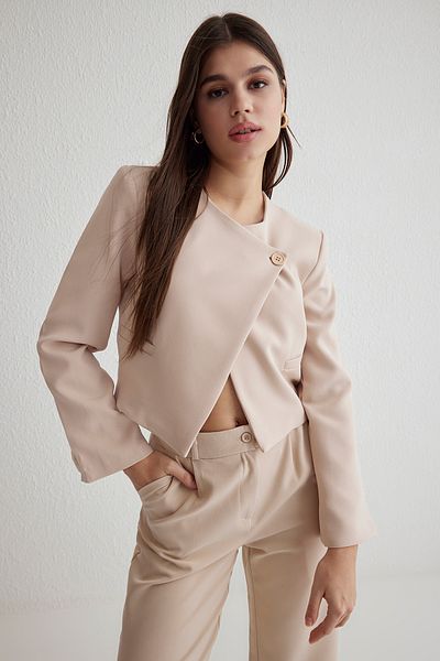 Trendyol Collection Beigefarbene Crop-Webjacke mit asymmetrischem Verschluss TWOSS25CE00035