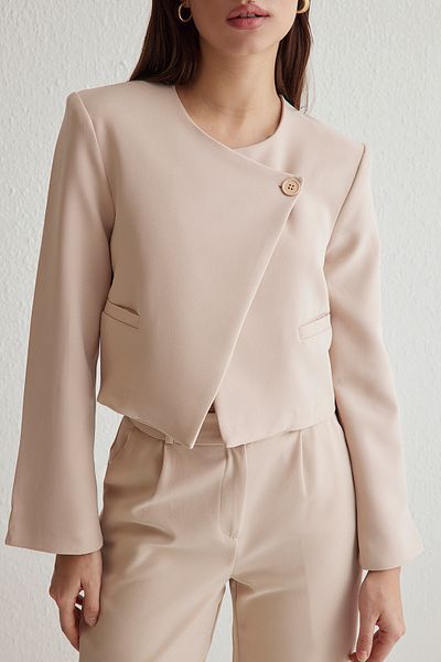 Trendyol Collection Beigefarbene Crop-Webjacke mit asymmetrischem Verschluss TWOSS25CE00035