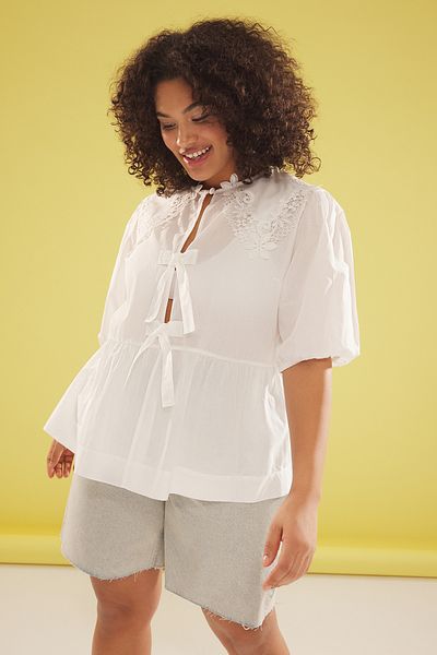 Trendyol Curve Weiße Brode-Bluse in Übergröße – Babyhalsband, Schleifendetail, kurze Ballonärmel, Voile TBBSS25AF00012