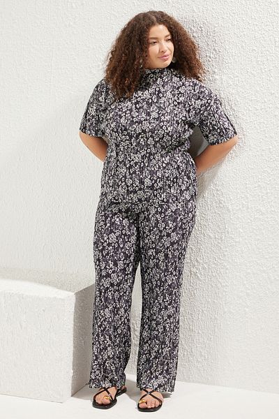 Trendyol Curve Schwarze, plissierte, gestrickte Bluse mit Blumendruck in Übergröße TBBSS25AF00084