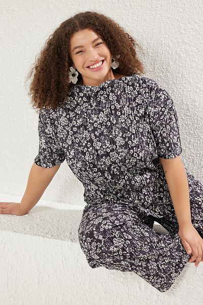 Trendyol Curve Schwarze, plissierte, gestrickte Bluse mit Blumendruck in Übergröße TBBSS25AF00084