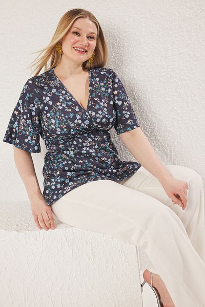 Trendyol Curve Blauer Blumendruck, zweireihiger Ausschnitt, Gips-Detail, gestrickte Bluse in Übergröße TBBSS25AF00083