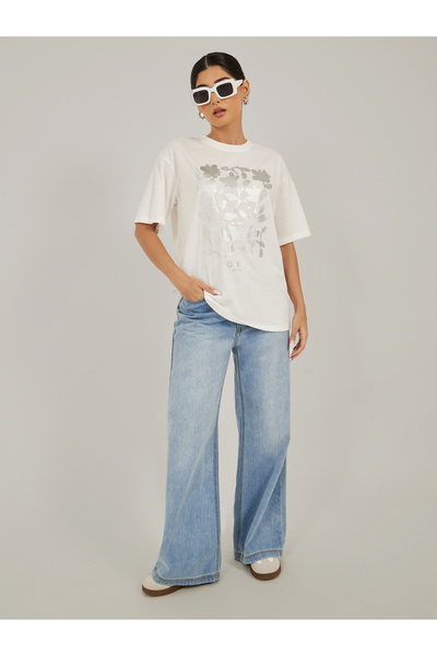 Styli تي شيرت كبير الحجم برقبة دائرية مزين برسومات زهور ورقائق معدنية