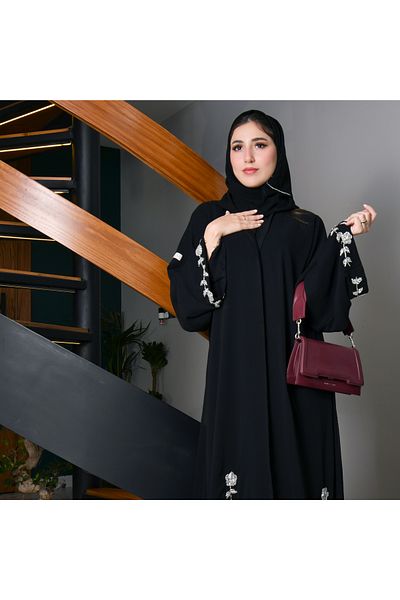 HAWRAA Black quarter-cloche wrap abaya decorated with elegant white and pink embroidery