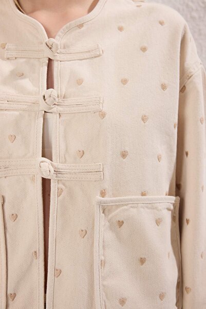 Kolekcia Trendyol Udržateľnejšia džínsová bunda s výšivkou srdca a detailom vrecka v ecru farbe TWOSS25CE00049