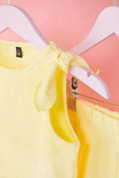 TRENDYOLKIDS شورت قصير من القطن الأساسي للفتيات باللون الأصفر بدون أكمام مع تفاصيل ربط بدلة علوية سفلية محبوكة TKDSS25AU00018