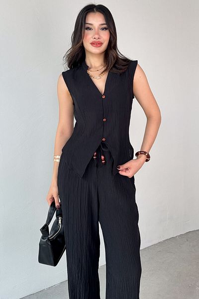 Cappmoda TKM-13314 سترة سوداء حديثة ذات ياقة محايدة وسروال فضفاض بتفاصيل ربط، طقم مكون من قطعتين