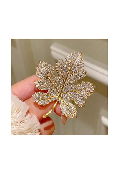 The Casius. Elegant maple leaf-shaped brooch with stones, refined accessory, 4 x 5 cm, gold color
