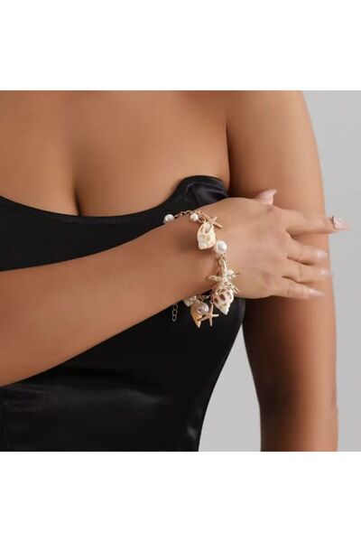Yıldız Accessory سوار Ocean Charm باللون الذهبي على شكل نجم البحر وقوقعة اللؤ...