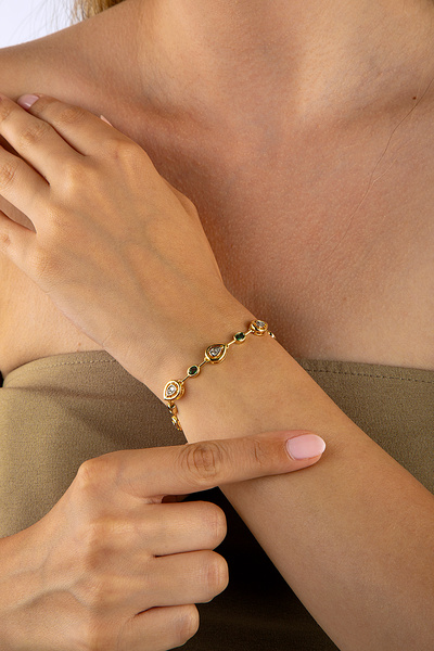 Innuendo سوار بيضاوي اللون باللون الذهبي مع حجر أخضر وحجر أبيض