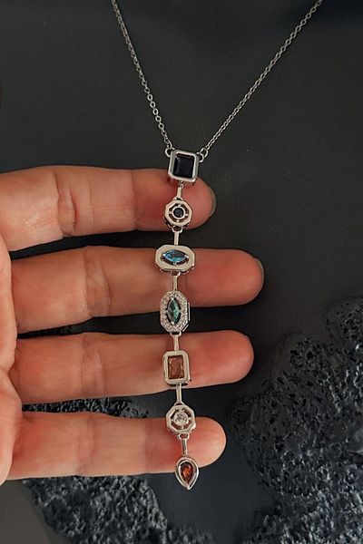 TAKIŞTIR قلادة فضية اللون من الفولاذ على شكل حرف Y مع تفاصيل حجرية ملونة