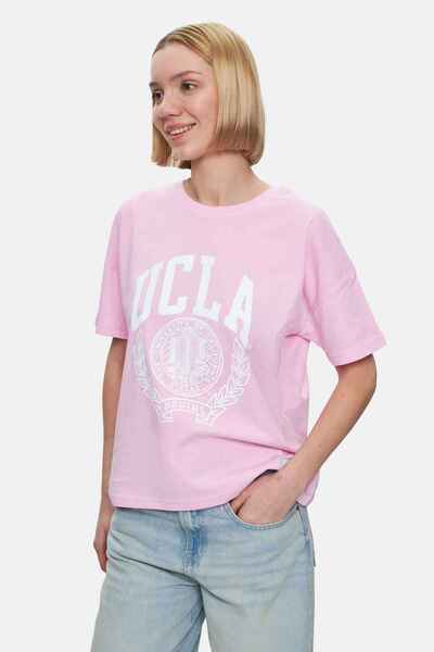 UCLA تي شيرت نسائي كبير الحجم مطبوع برقبة دائرية من AVALON باللون الوردي الفاتح