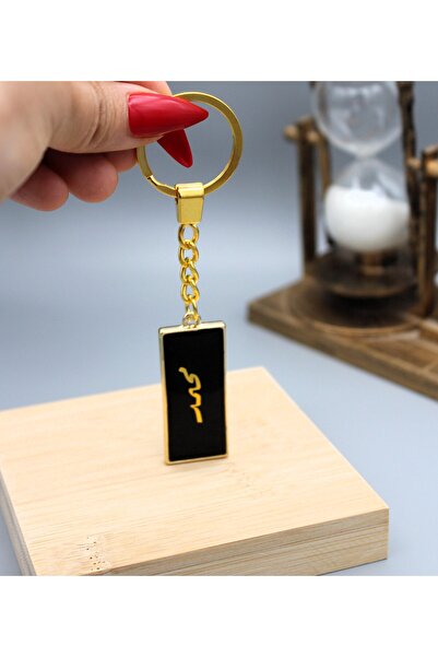 Roza ميدالية مفاتيح بتصميم انيق وخفيف باللون الاسود المطرز بالذهبي بإسم محمد