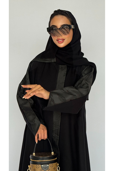 outline Black abaya with a central zipper and a quarter-circle with jacquard fabric overlay