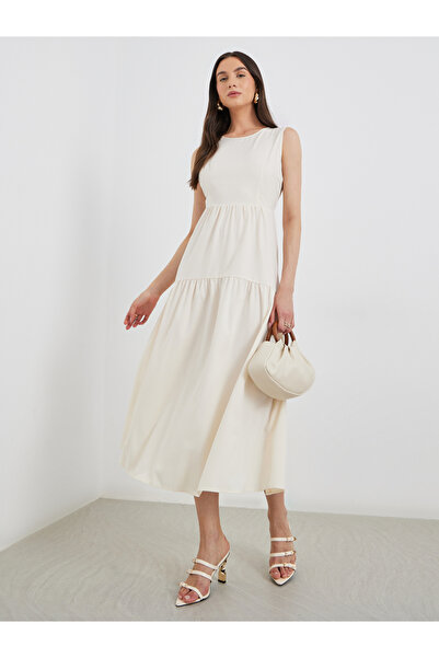 Styli فستان متوسط ​​الطول بيج سادة بدون أكمام