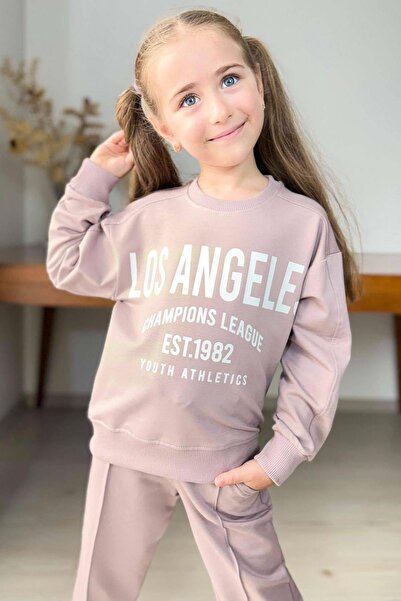 Riccotarz Κοριτσίστικο σετ αθλητικής φόρμας με λεπτομέρεια Los Angeles, με μανσέτες στα καρπά, φαρδιά εφαρμογή, σε σκόνη