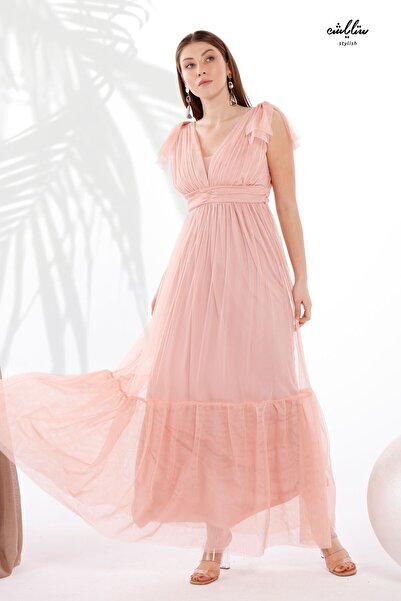 Stylish Feminine powder-colored long dress made of soft tulle, off-the-shoulder, with pleats around the waist and a flowing cut