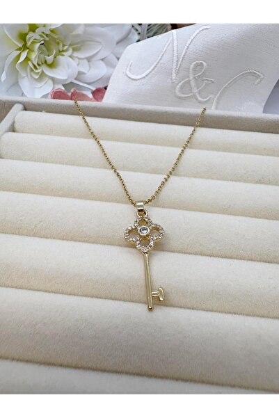 NUCA CO قلادة من الفولاذ باللون الذهبي مع شكل مفتاح وحجر الزركون