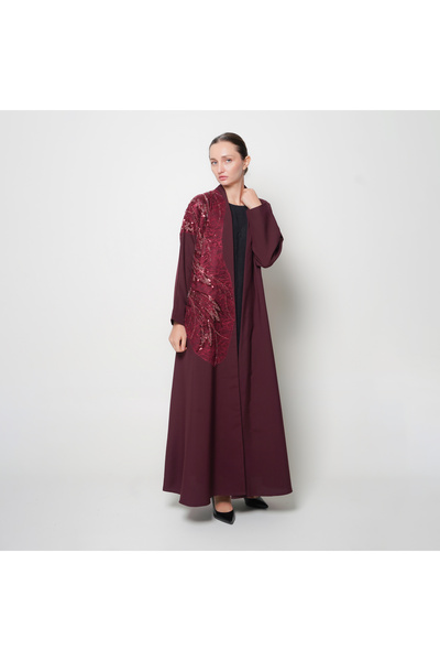 Oya.sa عباية راقية باللون العنابي بتصميم انيق وانسيابي بتداخل قماش على جانب العباية مزين بشك ترتر