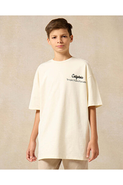 REDTAG تي شيرت كبير الحجم مطبوع عليه صورة ساحل كاليفورنيا الهادئ باللون الكريمي للأولاد الكبار