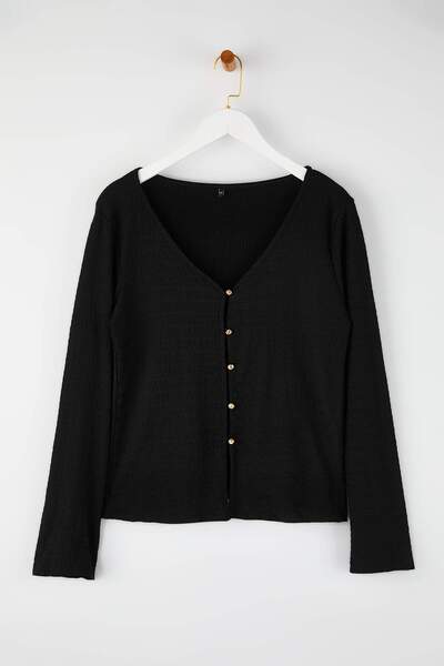 Trendyol Curve بلوزة سوداء بياقة على شكل حرف V مع تفاصيل إكسسوارات بأزرار منسوجة من قماش الجيرسيه مقاس كبير TBBAW26AF00068