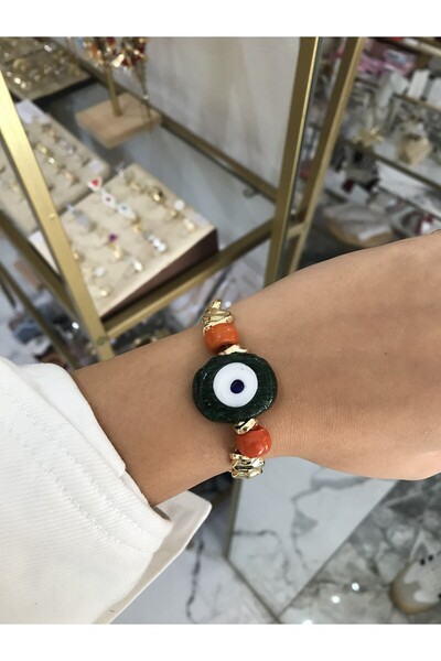 the ASEL İNCİ سوار مطاطي بتصميم العين الخضراء مع تفاصيل ذهبية وبرتقالية