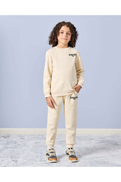 REDTAG طقم بنطال رياضي كاجوال مطبوع باللون العاجي للأولاد (قطعتين)